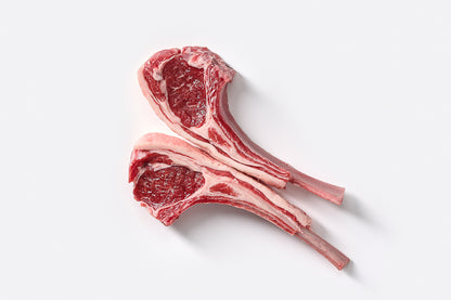 Two Australian lamb chops with visible bone, isolated on a white background.