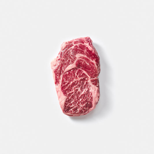 Raw steak with marbling on a light gray background